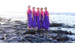 five hula girls with matching purple dresses