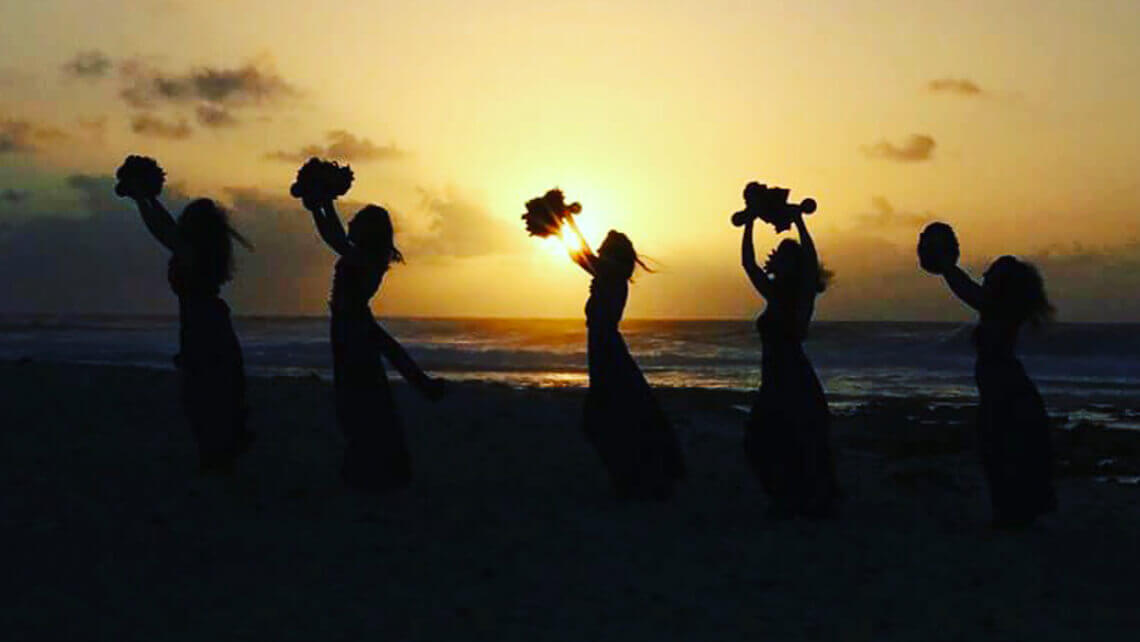 hula dancers in sunset on beach