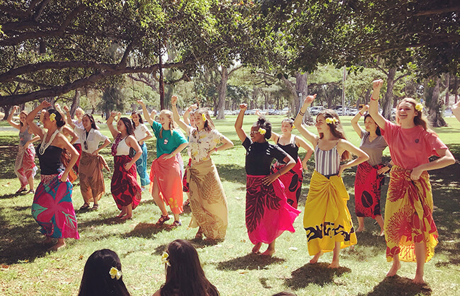 group of friends learning the hula on lawn