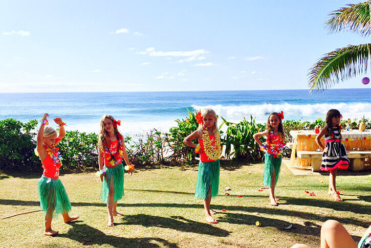 little girls dancing the hula by the ocean