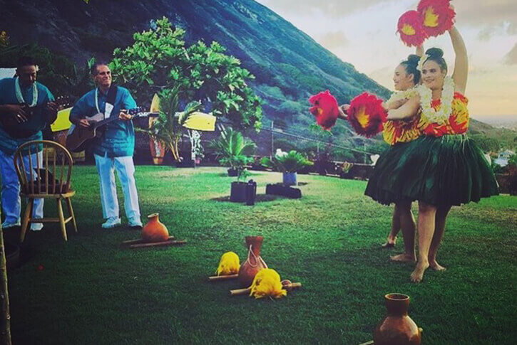 hula dancers performing on stage at a luau