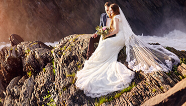 wedding couple on rocks near sea