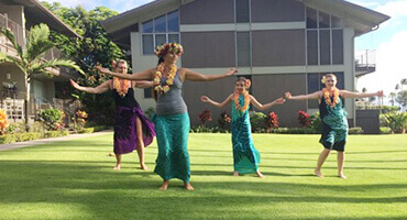 family learning hula with hula dancer